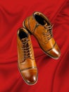 A pair of premium calfskin boots on a red background. Vertical shot.