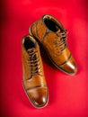A pair of premium calfskin boots on a red background. Vertical shot.