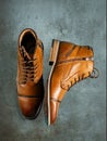 A pair of premium calfskin boots on a stone background. Vertical shot.