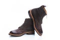 Pair of Premium Dark Brown Grain Brogue Derby Boots Made of Calf Leather with Rubber Sole Placed Over One Another Over White