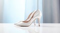 a pair of pristine white high heel bridal shoes on a white surface for a minimalistic, elegant composition that embodies