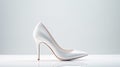 a pair of pristine white high heel bridal shoes on a white surface for a minimalistic, elegant composition that embodies