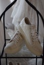 Pair of pristine white sports shoes resting in a display in Wedding store