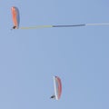 Pair of reckless pilots performs aerial acrobatics on board paramotors with the use of a banner Royalty Free Stock Photo