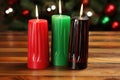 a pair of red, black, and green kwanzaa candles on a wooden table