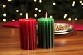 a pair of red, black, and green kwanzaa candles on a wooden table Royalty Free Stock Photo