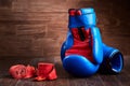 Pair of red and blue boxing gloves and red bandage on brown plank. Royalty Free Stock Photo