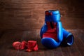 Pair of red and blue boxing gloves and red bandage on brown plank. Royalty Free Stock Photo