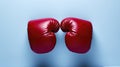 pair of red boxing gloves touching at the knuckles, set against a solid blue background, ai generative Royalty Free Stock Photo