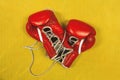 Pair of red boxing gloves, worn out, with laces untied