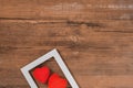 Pair of red hearts in white frame on vintage wooden table, top view. Saint Valentines day background Royalty Free Stock Photo