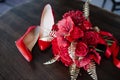 A pair of red high-heeled shoes with a bouquet on the table Royalty Free Stock Photo