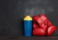 Pair of red leather boxing gloves and blue plastic bottle Royalty Free Stock Photo