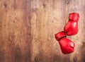 Pair of red leather boxing gloves hanging on a nail on a wooden wall. Royalty Free Stock Photo