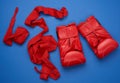 Pair of red leather boxing gloves and a textile red elastic bandage for hands lie on a blue background Royalty Free Stock Photo