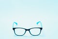 Pair of red plastic-rimmed eyeglasses on a blue background