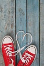 A pair of red retro sneakers on a blue wooden background, laces Royalty Free Stock Photo