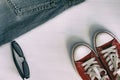 Pair of red sneakers, retro fragment jeans, black sunglasses on Royalty Free Stock Photo