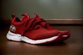 A Pair Of Red Sneakers Sitting On Top Of A Wooden Floor. Generative AI Royalty Free Stock Photo