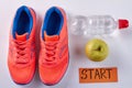 Pair of red sport shoes with water bottle and green apple. Royalty Free Stock Photo