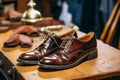 Pair of restored male leather shoes on table at workshop. Generative AI