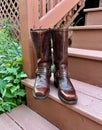 Pair of Retro Brown Western or Harness Boots on Wooden Steps Royalty Free Stock Photo