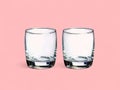 Pair of Round Clear Drinking Glasses on Pink Background Royalty Free Stock Photo