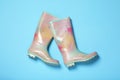 Pair of rubber boots on light blue background, top view Royalty Free Stock Photo