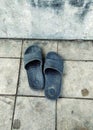 A pair of sandals that are used for footwear and are black on the floor