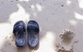 Pair of sandals on the white sand beach in the morning Royalty Free Stock Photo