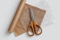A pair of scissors, bubble wrap, and craft paper arranged on a white background create a stylish packaging mockup Royalty Free Stock Photo