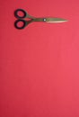 Pair of scissors gold isolated on red background, copy space