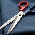 A pair of scissors with one red handle and one blue handle is placed on dark blue Royalty Free Stock Photo