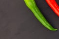 Pair of sharp peppers pepper red green chili part of a vegetable decoration culinary design on a black background, slate base copy