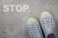 Pair of shoes standing on a road with STOP concept