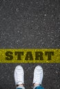 Pair of shoes standing on a road with the word START