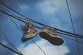 A pair of shoes suspended from a power line in an urban setting, Basketball shoes hanging off a telephone wire, detailed stitching Royalty Free Stock Photo