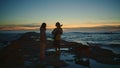 Pair silhouettes dating sunset beach. Woman enjoying music man playing guitar Royalty Free Stock Photo