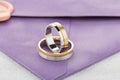 Pair of silver and gold combined rings on purple invitation envelope