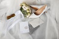 a pair of wedding shoes , a bouquet of flowers , a wedding invitation , and a pair of wedding rings Royalty Free Stock Photo