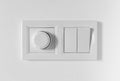 Pair of simple light switches with dimmer. Inexpensive plastic mechanical double switch with thermostat against white