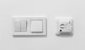 Pair of simple light switches with dimmer. Inexpensive plastic mechanical double switch with thermostat against white