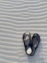 Pair of slippers on a wavy sand