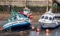 Pair of small fishing boats grounded at high tide in West Bay harbour, Dorset, UK