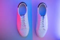 Pair of sneakers on color background, top view