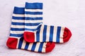 A pair of socks on a gray cement background. Blue and beige striped socks with a red toe and heel Royalty Free Stock Photo