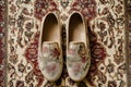 pair of soft beige floral print slip on shoes on a vintage patterned carpet