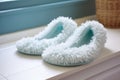 a pair of spa-style slippers on a white chenille bath mat Royalty Free Stock Photo