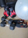 Pair of sport shoes, boxing gloves, hex dumbbell weights laid on floor carpet