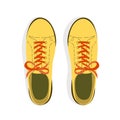 A pair of sport style yellow shoes with shoelaces top view.